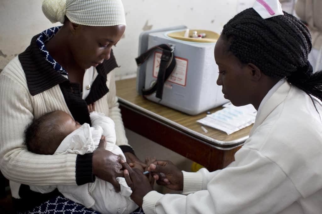 Above: A child receives a vaccine at a health center in Ishaka Mberare, Uganda. (Photo courtesy of Kate Holt/MCSP.)