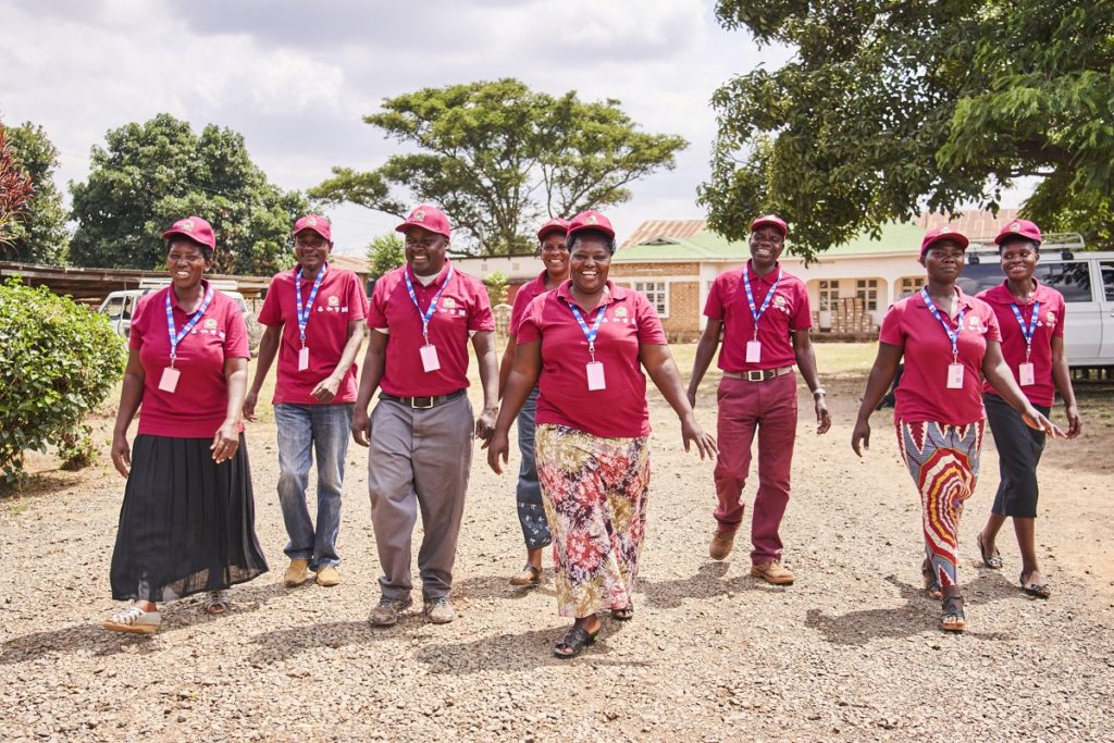 A group of Ugandan healthcare workers wearing maroon polos.