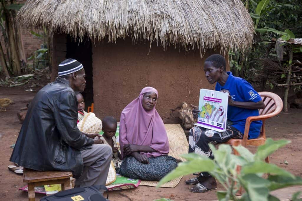 VHT Esereda Sanyu, takes the family of Faisal Musana throgh a health education on malaria during a vist at their home in Nalukelo village, Bulage Sub County, Namutumba district on 5th May 2024. “We no longer fall sick of malaria since she taught us. She comes to check on us regularly to se if we are following the guidelines” he said. Namutumba district in Busoga region is one of the high malaria burden districts. Through VHTs, PMI has supported the district in training communities in malaria management, the staff in records and malaria commodity stock management. Photo by Jimmy Adriko