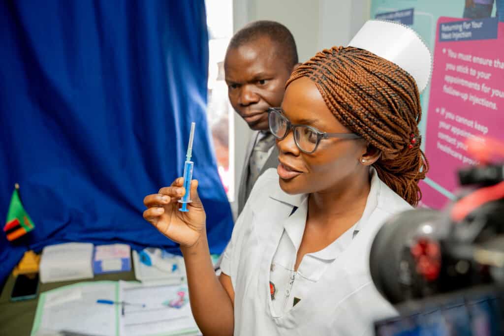 A nurse holds a syringe in her hand