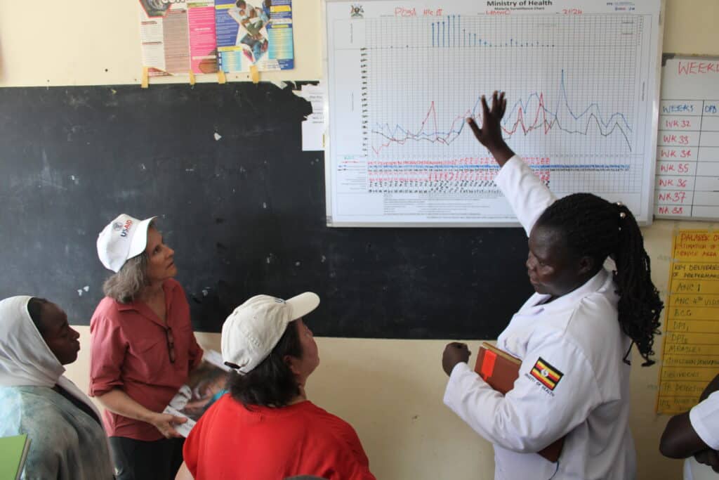 A group of people look at a chart on the wall.