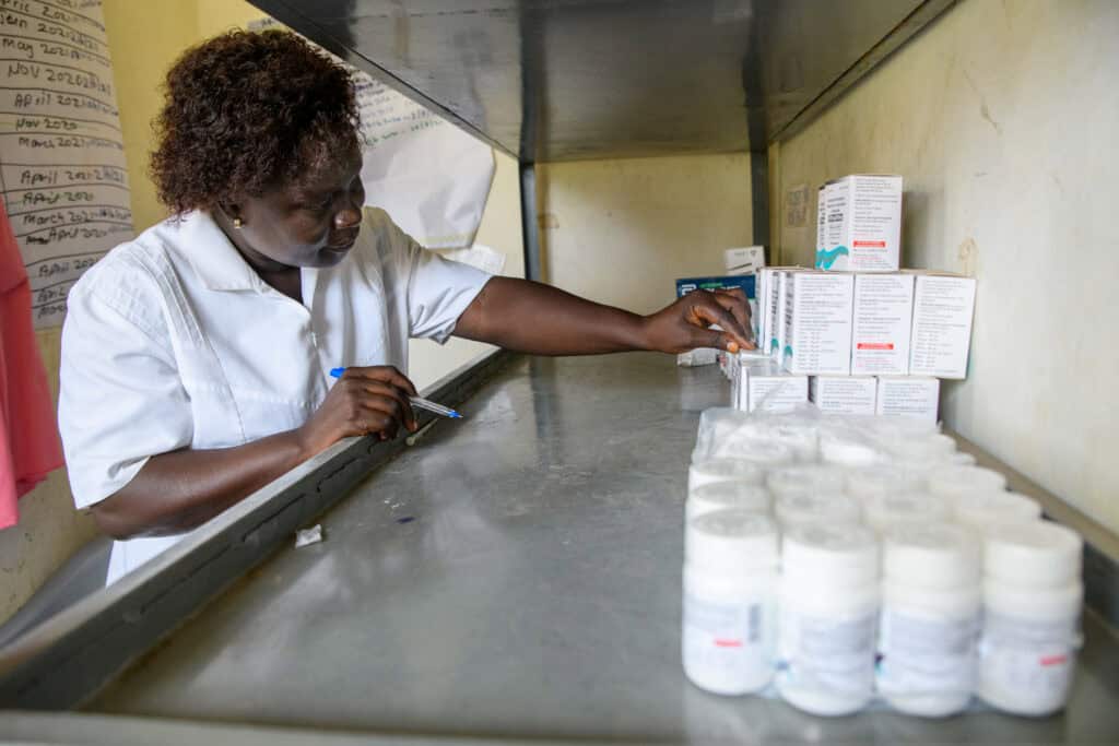 A health worker conducts stock taking for antiretroviral drugs in Dokolo Health Center IV in Uganda. The USAID RHITES-N, Lango project supported districts and health facilities to ensure the availability and accessibility to essential medicines and health supplies to improve health services. Photo by Malaika Media for JSI