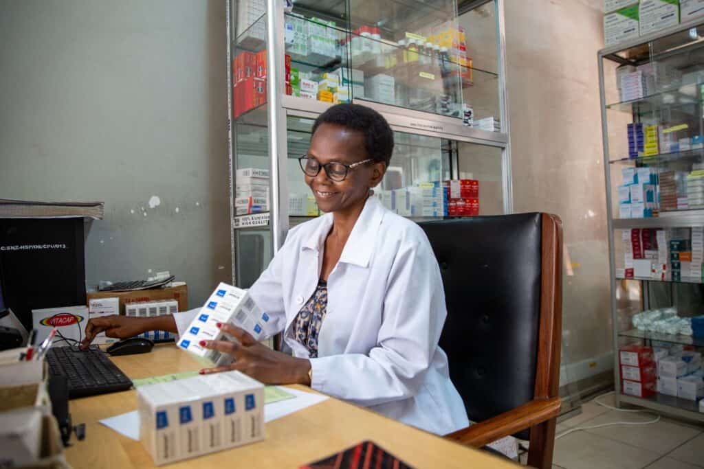 A female health care worker sits at a desk looking at medications