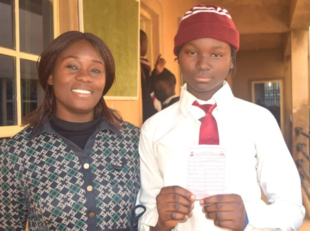 A Nigerian schoolboy poses with a female teacher