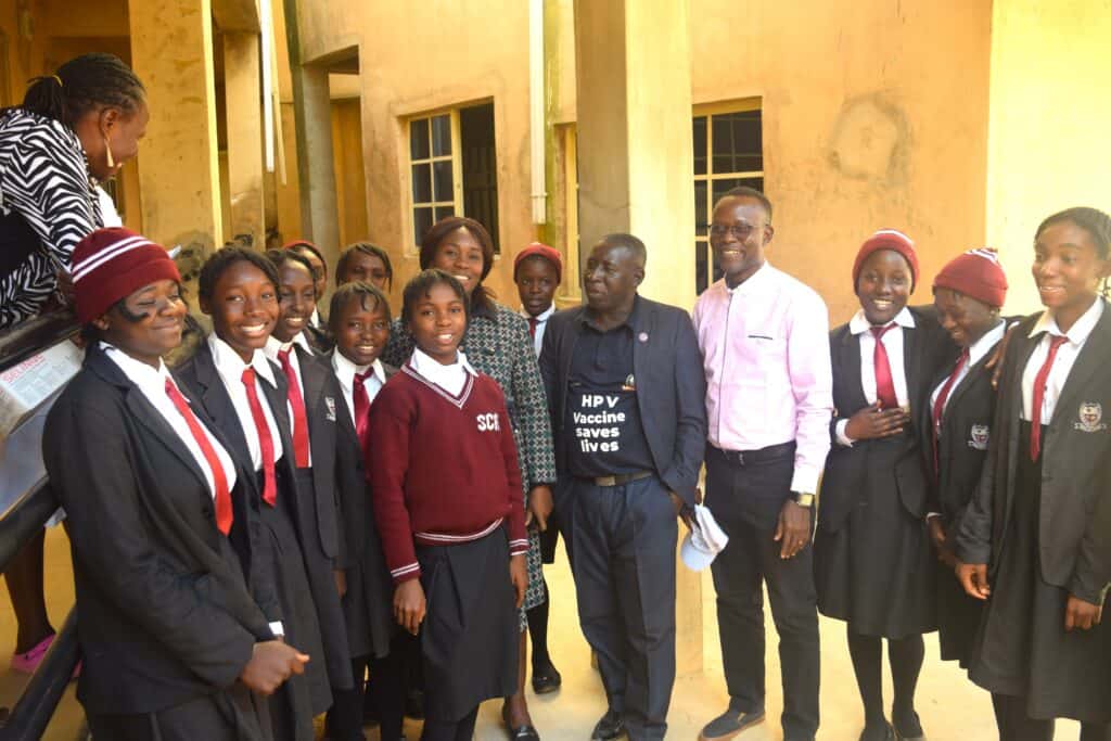 A group of Nigerian school children pose for a photo with administrators.